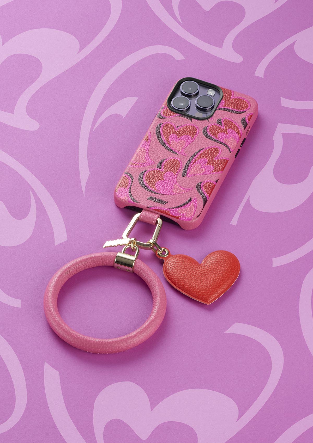 Untags case for iPhone 14 Pro in pink color with hearts and Phone Bangle and charm accessories