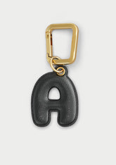 Charm Untags per iPhone a forma di lettera A, effetto pelle in colore nero, con moschettone per attaccare l’accessorio alla cover