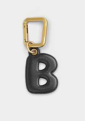 Charm Untags per iPhone a forma di lettera B, effetto pelle in colore nero, con moschettone per attaccare l’accessorio alla cover