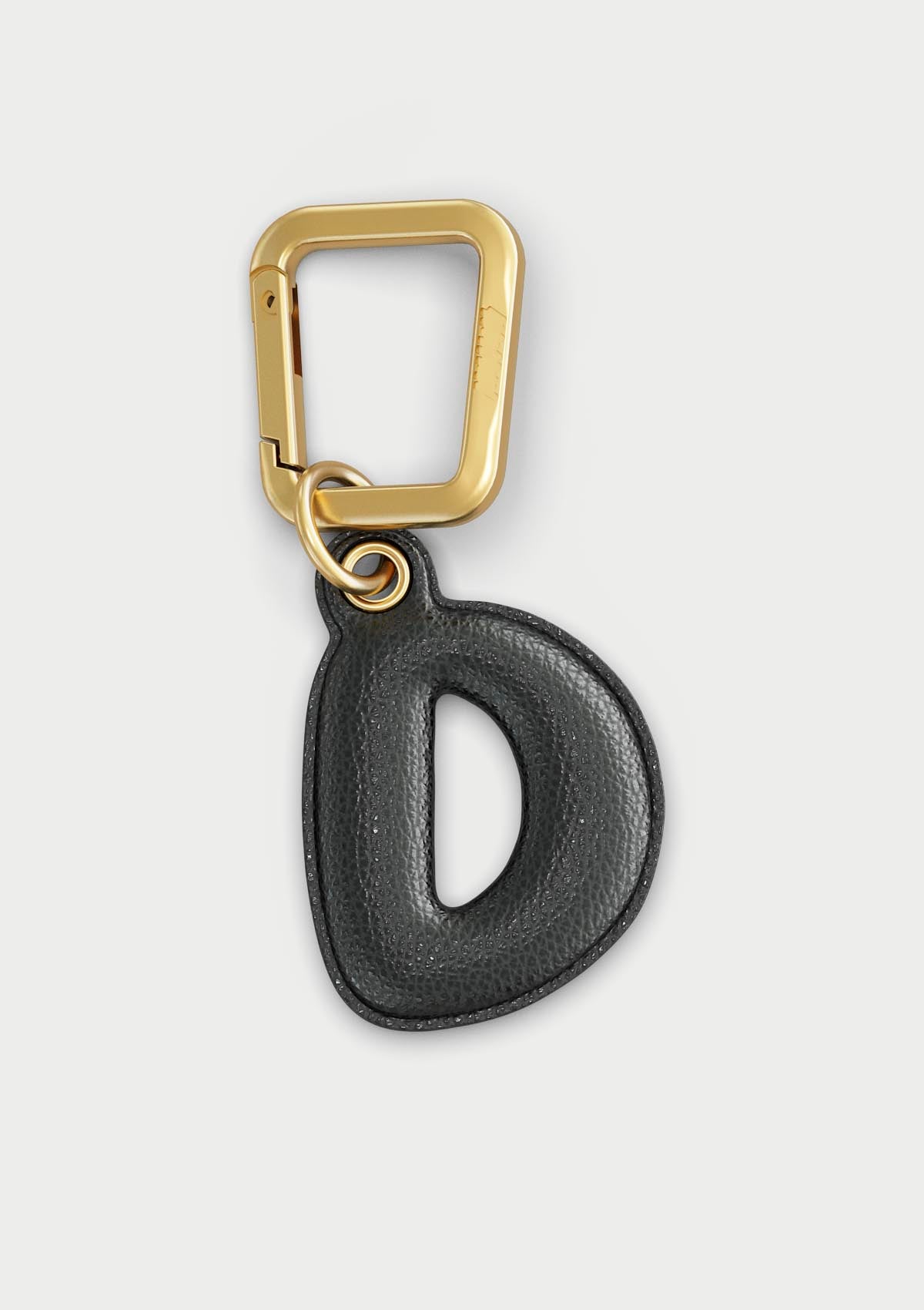 Charm Untags per iPhone a forma di lettera D, effetto pelle in colore nero, con moschettone per attaccare l’accessorio alla cover