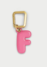 Charm Untags per iPhone a forma di lettera F, effetto pelle in colore rosa, con moschettone per attaccare l’accessorio alla cover