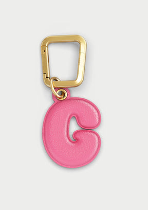 Charm Untags per iPhone a forma di lettera G, effetto pelle in colore rosa, con moschettone per attaccare l’accessorio alla cover