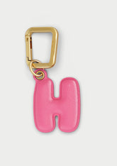 Charm Untags per iPhone a forma di lettera H, effetto pelle in colore rosa, con moschettone per attaccare l’accessorio alla cover