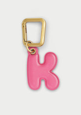 Charm Untags per iPhone a forma di lettera K, effetto pelle in colore rosa, con moschettone per attaccare l’accessorio alla cover
