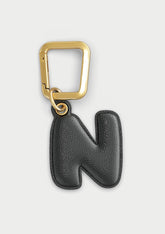 Charm Untags per iPhone a forma di lettera N, effetto pelle in colore nero, con moschettone per attaccare l’accessorio alla cover