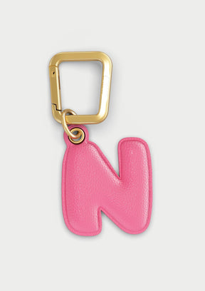 Charm Untags per iPhone a forma di lettera N, effetto pelle in colore rosa, con moschettone per attaccare l’accessorio alla cover