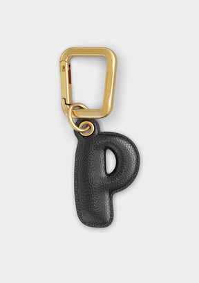 Charm Untags per iPhone a forma di lettera P, effetto pelle in colore nero, con moschettone per attaccare l’accessorio alla cover