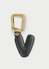 Charm Untags per iPhone a forma di lettera V, effetto pelle in colore nero, con moschettone per attaccare l’accessorio alla cover
