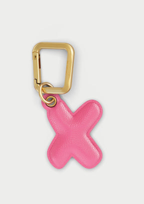 Charm Untags per iPhone a forma di lettera X, effetto pelle in colore rosa, con moschettone per attaccare l’accessorio alla cover